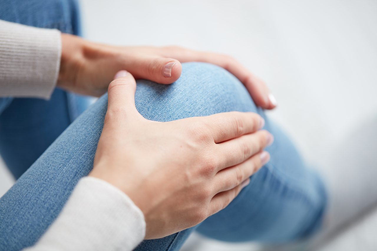 A woman massaging her own knee.