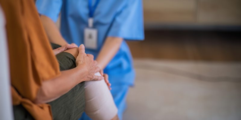 A medical professional in blue uniform with a patient.