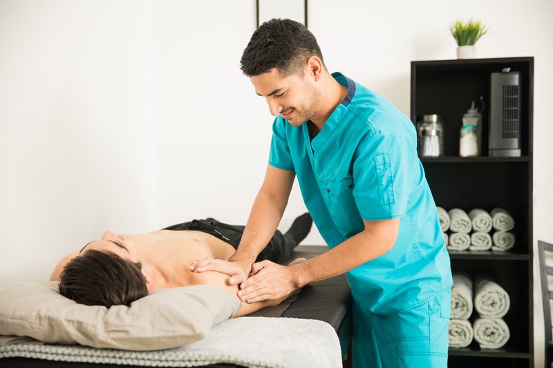 A therapist massaging an athlete's shoulder.