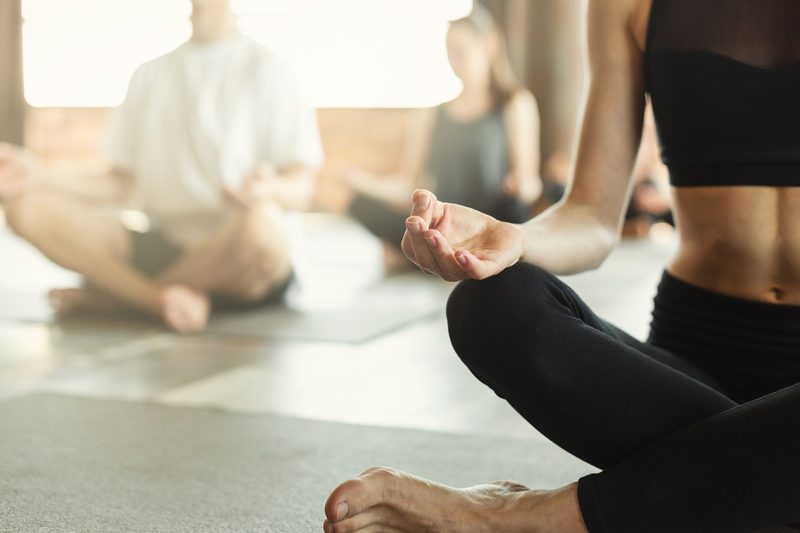 Two people meditating peacefully indoors during a yoga session.